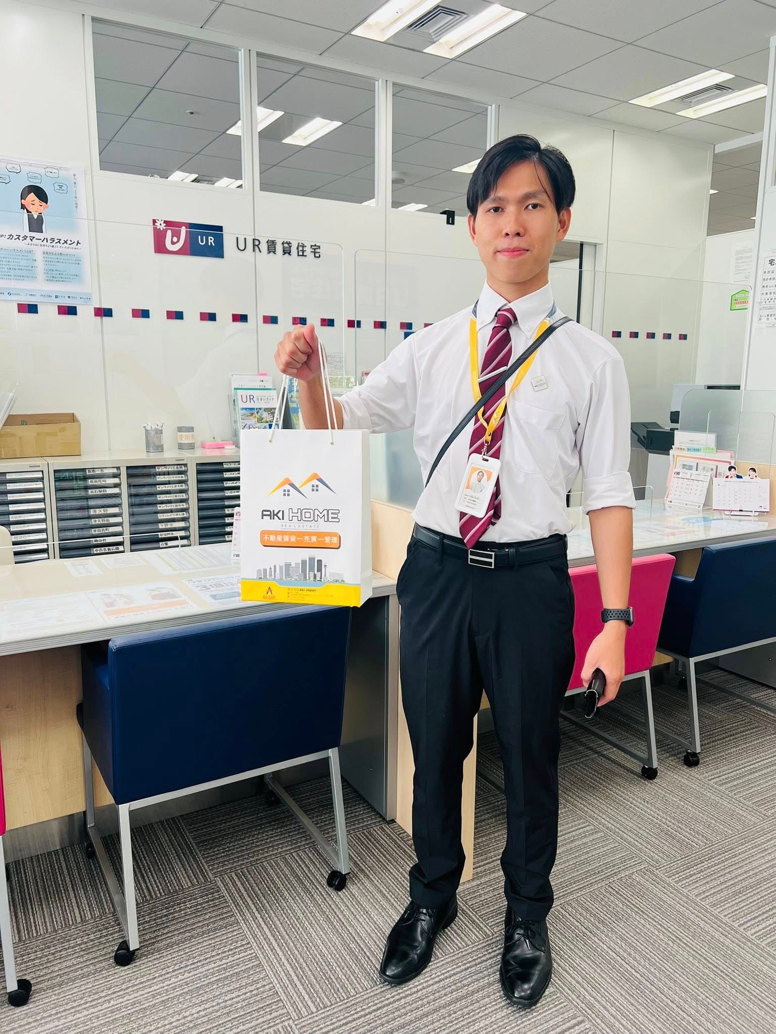 AKI HOME staff member at a UR rental-housing counter — trusted multilingual insurance and policy guidance